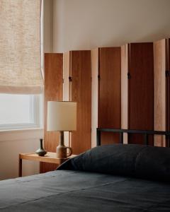 a bedroom with a bed with a lamp and wooden cabinets at The James Bradley in Bradley Beach +19 photos