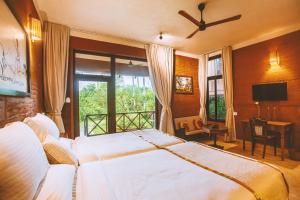 コバラムにあるAMARA AYURVEDA RETREAT- Overlooking Evergreen Western Ghats an ecologically sustainable living space in Kovalamのベッドルーム1室(ベッド2台、窓付)