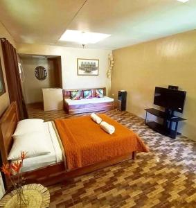 a hotel room with a bed and a flat screen tv at Casa de Cortijo in Pagbilao