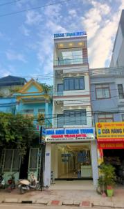 a tall building with signs on the side of it at Nhà Nghỉ QUANG TRUNG in Dồng Văn