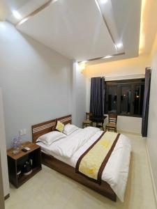 sypialnia z dużym łóżkiem i stołem w obiekcie Nhà Nghỉ QUANG TRUNG w mieście Dồng Văn