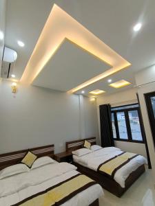 ドン・ヴァンにあるNhà Nghỉ QUANG TRUNGの大きな天井の客室で、ベッド2台が備わります。