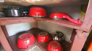 a group of red pots and pans sitting on a shelf at Calatagan's Bahay Kubo - with Beach Access in Calatagan