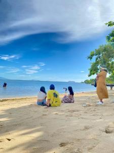 eine Gruppe von Menschen am Strand in der Unterkunft Calatagan's Bahay Kubo - with Beach Access in Calatagan