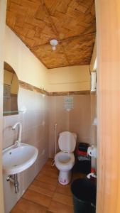 a bathroom with a white toilet and a sink at Calatagan's Bahay Kubo - with Beach Access in Calatagan