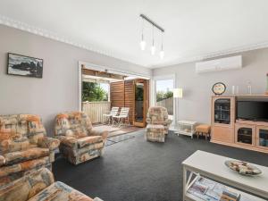 a living room with couches and a tv at Resarf Retreat in Portarlington