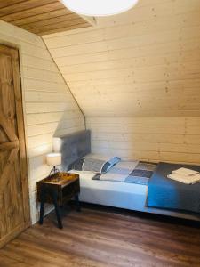 1 dormitorio con 1 cama y 1 mesa en una habitación en Modrynowe Domki en Wetlina