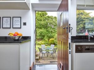 a kitchen with a door leading to a patio at Millie's Cottage in Oldham