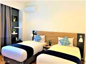 dwa łóżka siedzące obok siebie w pokoju w obiekcie Chateau Bleu Resort w mieście Calamba