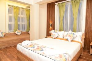 um quarto com uma cama e duas janelas em Janeira em Shillong