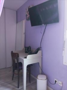 a room with a desk with a monitor on the wall at Chez Fanny Chambres d'hôtes in Fos-sur-Mer