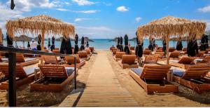 a row of chairs and umbrellas on a beach at Varkiza Cozy Seaside Apartment in Vari