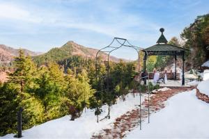 Taj Theog Resort & Spa Shimla في شيملا: شرفة في الثلج مع الجبال في الخلفية