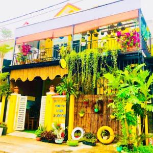 會安的住宿－An Bang Sea Adventure Homestay Hoi An，一座黄色的建筑,前面有植物