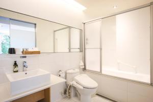 Baño blanco con lavabo y aseo en Dandy Hotel-Daan Park Branch, en Taipéi