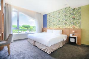 a hotel room with a bed and a large window at Dandy Hotel-Daan Park Branch in Taipei