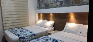 a hotel room with two beds and a headboard at Casa Paraíso Habitaciones en el Centro de Ciudad Valles in Ciudad Valles