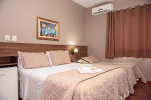 a bedroom with a bed with a towel on it at CAMBRAIA HOTEL ARCOS in Arcos