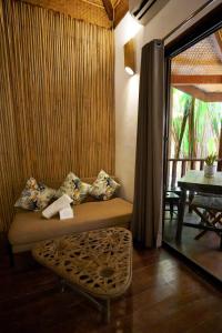 a living room with a couch and a table at Fisheye The Rooms - Family room in El Nido