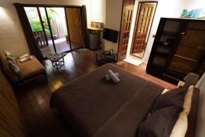 uma sala de estar com uma cama e um sofá em Fisheye The Rooms - Family room em El Nido