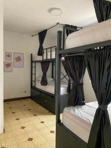 2 stapelbedden met gordijnen in een kamer bij La Palmera Hostel in Cali