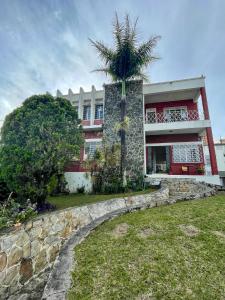 a house with a palm tree in front of it at La Palmera Hostel in Cali