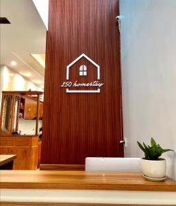 uma porta de madeira com uma placa de casa em 150 Homestay em Dong Hoi