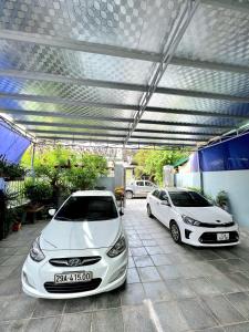dos autos blancos estacionados en un estacionamiento en 150 Homestay en Ðồng Hới