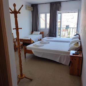 una camera d'albergo con due letti e una finestra di Hotel Ilion a Pétra