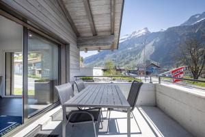 een tafel en stoelen op een balkon met uitzicht op een berg bij Moto-Center BeO AG (Bike & Bed) in Brienz