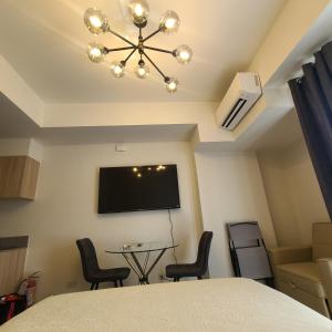 a room with a tv and a table and chairs at INSPIRIA Condo Free Airport Pickup for 3 nights stay or more in Davao City