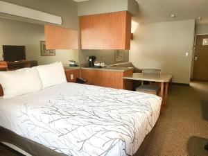 a hotel room with a bed and a kitchen at Monument Inn & Suites in Gering