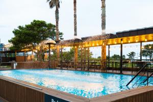 uma grande piscina com luzes num edifício em Benikea Hotel Jeju em Jeju