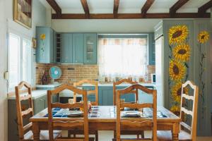 a kitchen with a table and chairs and a kitchen with blue cabinets at Villa “Alexis&Coco” traditional house in Tríkorfon