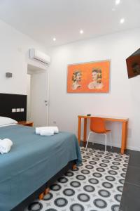 a bedroom with a bed and a desk with a chair at Zagara e Lumia in Catania