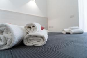 a pile of white towels sitting on a bed at Zagara e Lumia in Catania