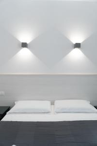 a white bed with two lights on top of it at Zagara e Lumia in Catania