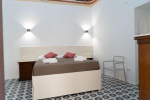 a bedroom with a bed and a desk and a chair at Zagara e Lumia in Catania