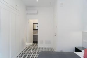 a bedroom with white walls and a black and white floor at Zagara e Lumia in Catania