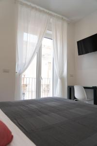a bedroom with a bed and a large window at Zagara e Lumia in Catania