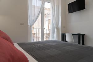 a bedroom with a bed and a large window at Zagara e Lumia in Catania