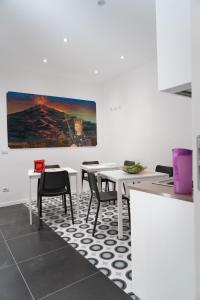 a dining room with white tables and chairs and a painting at Zagara e Lumia in Catania
