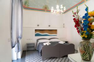 a bedroom with a bed and a vase of flowers at Zagara e Lumia in Catania