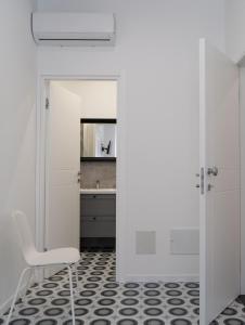 a white kitchen with a chair and a sink at Zagara e Lumia in Catania