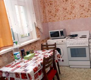 モスクワにあるApartment on Molodyozhnayaのキッチン(テーブル、コンロ、電子レンジ付)
