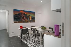a dining room with two tables and a painting on the wall at Zagara e Lumia in Catania