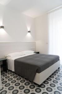 a bedroom with a large bed with two lights above it at Zagara e Lumia in Catania