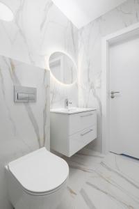 biała łazienka z toaletą i umywalką w obiekcie Apartament DIAMOND w Kołobrzegu +12 zdjęć