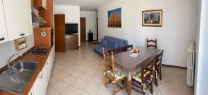 cocina y sala de estar con mesa y sofá en Condominio tigli, en Cavalcaselle