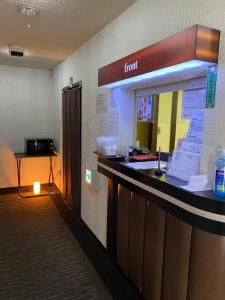 a front desk of a hotel with a sign on the wall at Oyado Cocochi in Tokyo